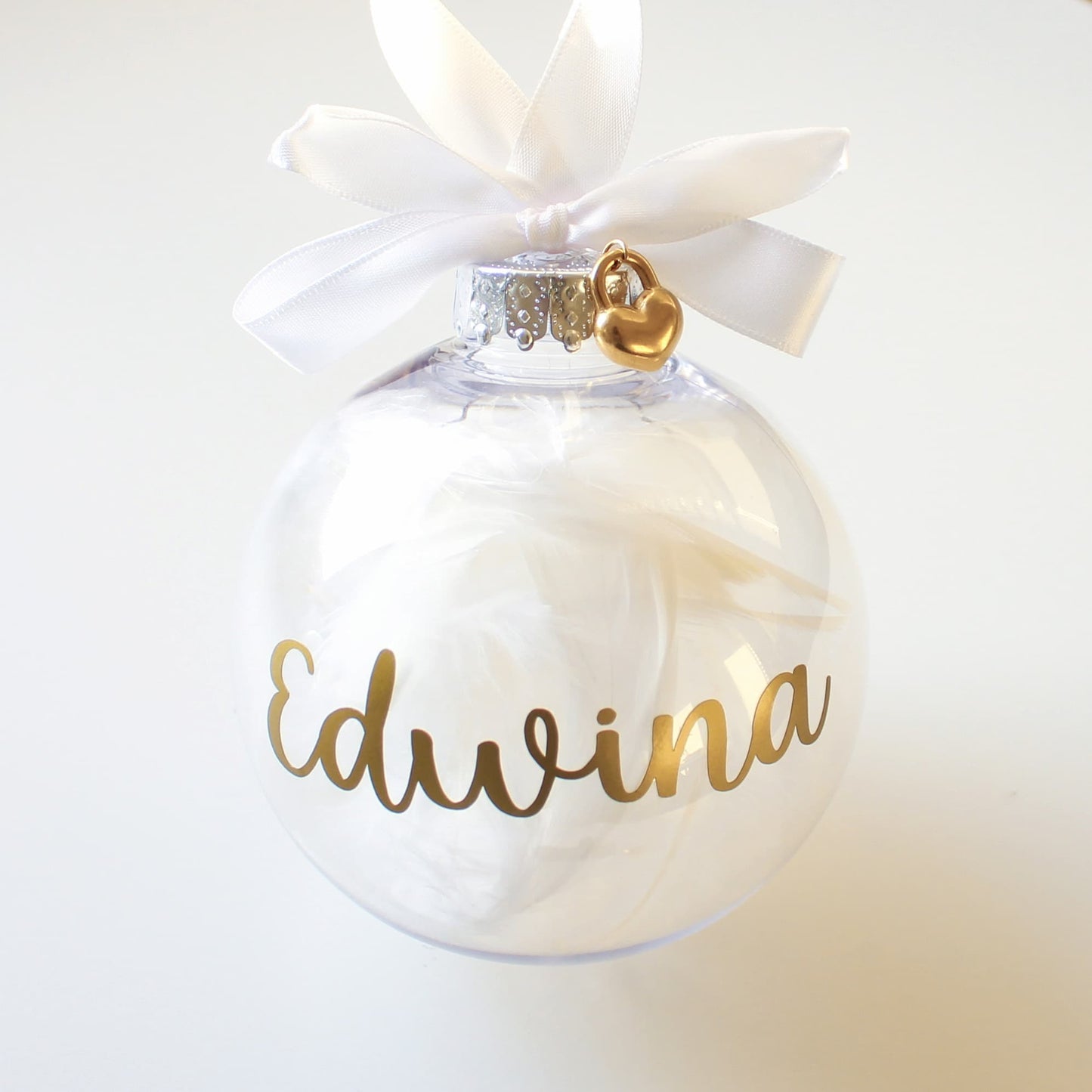 feather ornament with 'Edwina' written on it, featuring a white ribbon and gold heart charm.