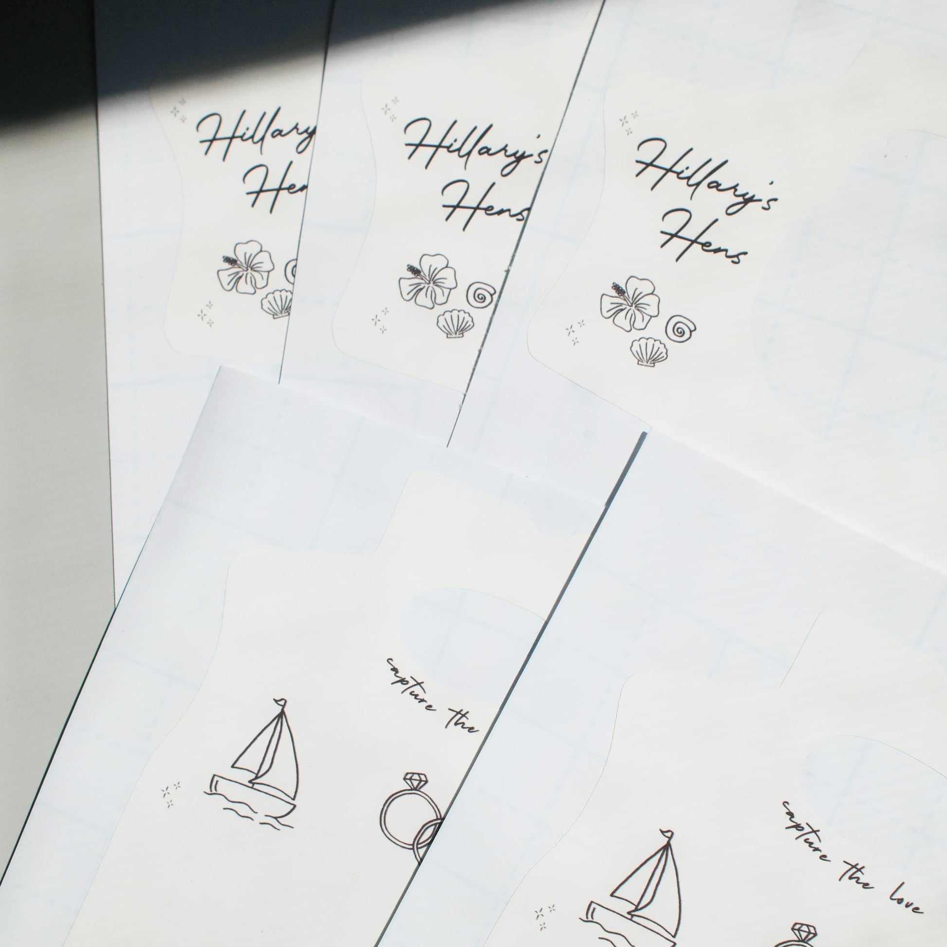 disposable camera wrap stickers with sailboat and ring illustrations and 'Hillary's Hens' text.