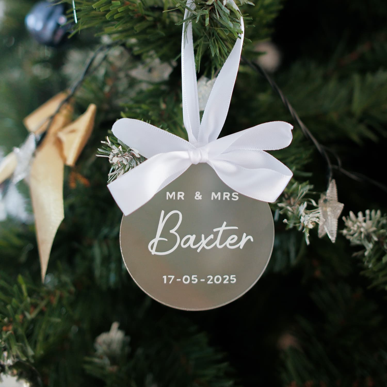 Decorative ornament with 'MR & MRS Baxter' and date on a Christmas tree.