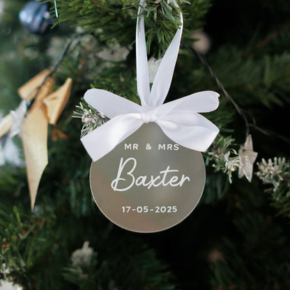 Decorative ornament with 'MR & MRS Baxter' and date on a Christmas tree.