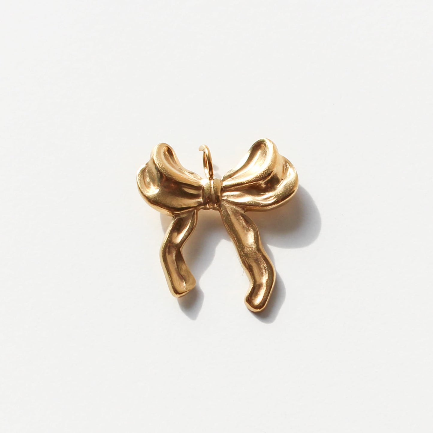 Gold bow-shaped pendant on a white background
