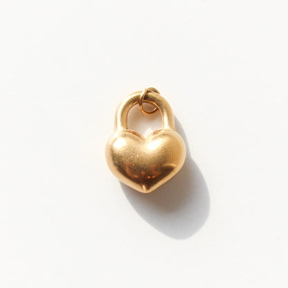 Gold heart-shaped lock charm on a white background