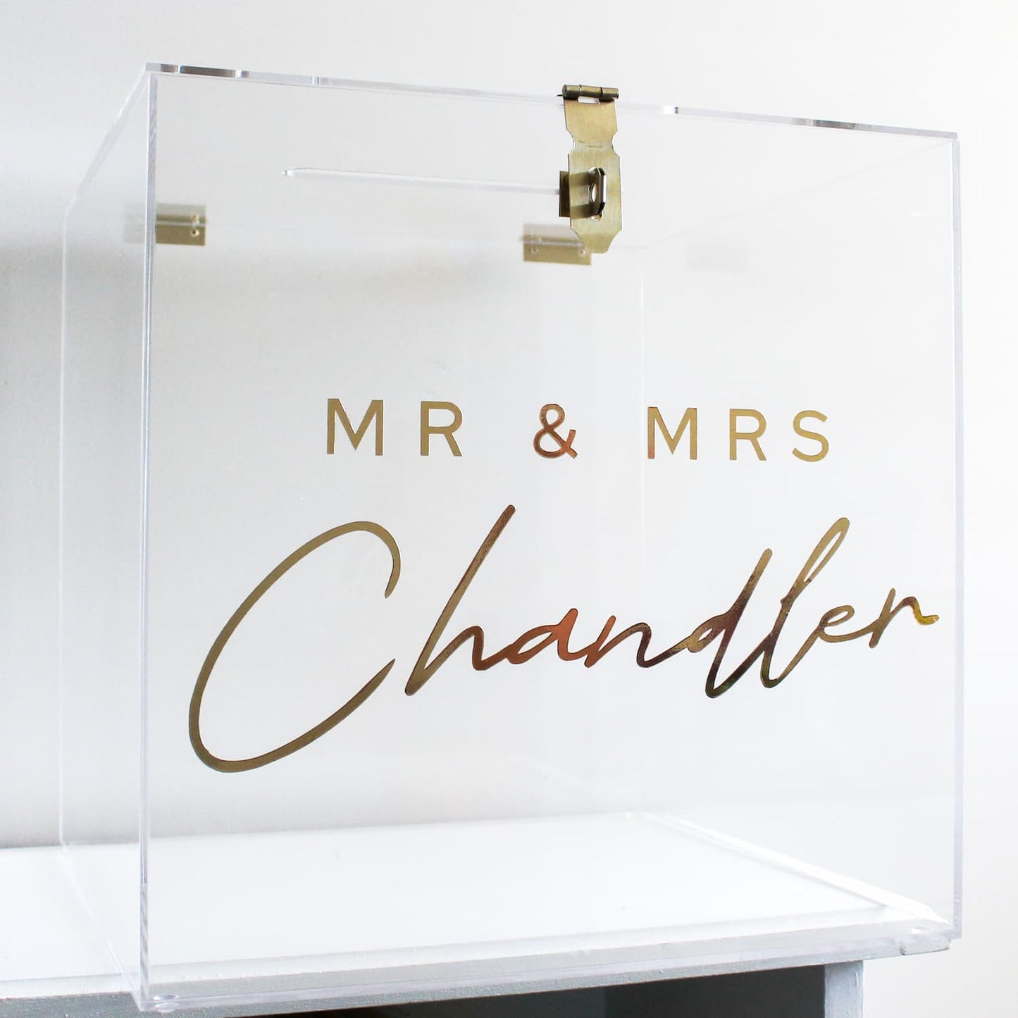 Clear acrylic wishing well box with 'MR & MRS Chandler' in gold text on a white background