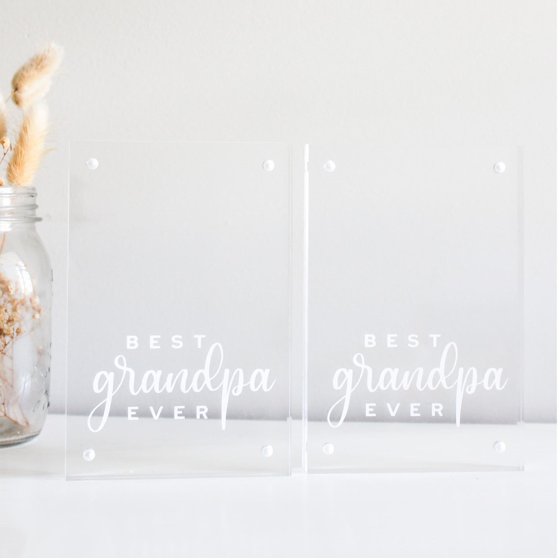 Two clear acrylic blocks with 'Best Grandpa Ever' text and a jar with dried plants on a light background.
