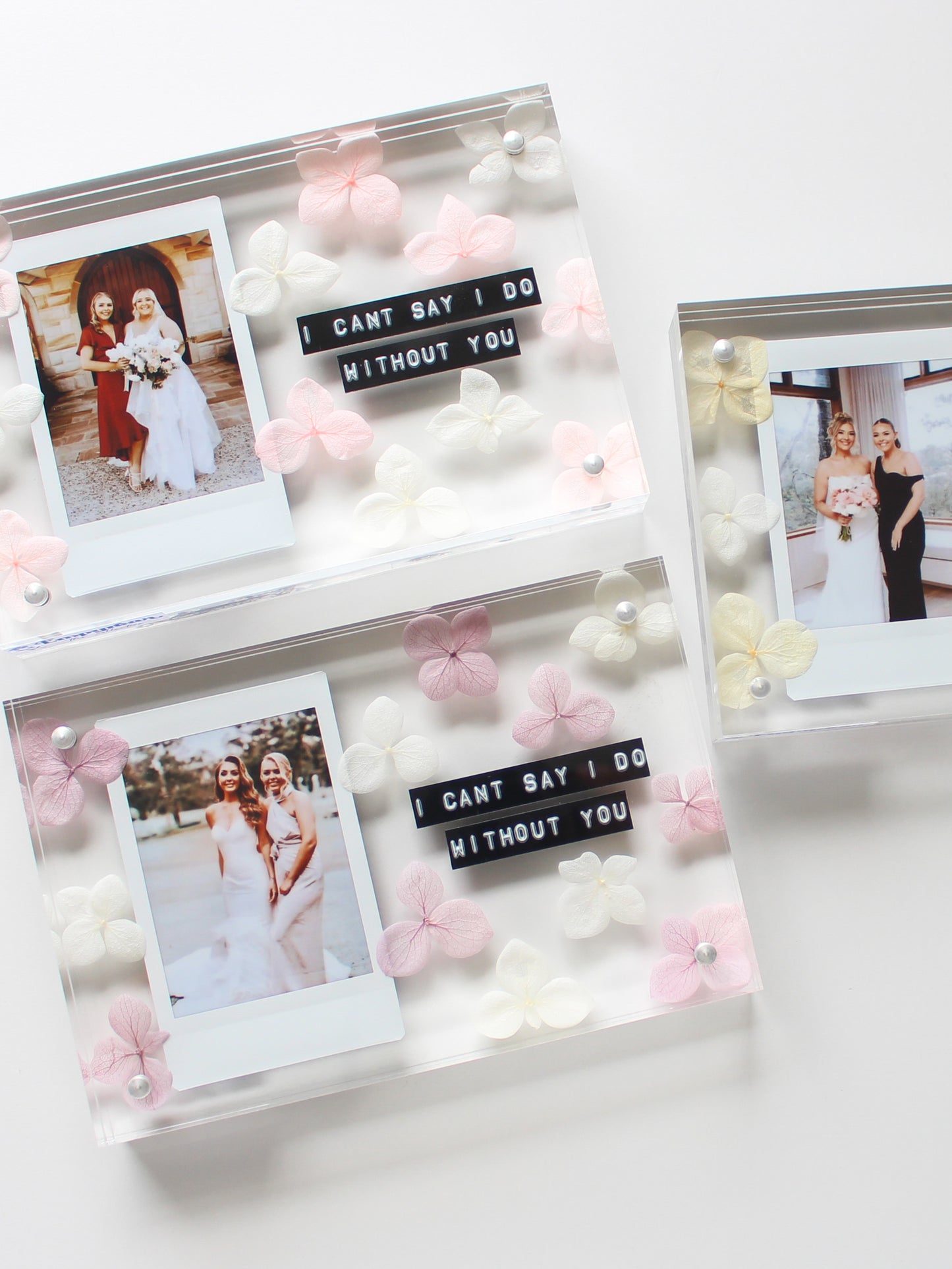 Decorative photo display with wedding photos and 'I can't say I do without you' sign.