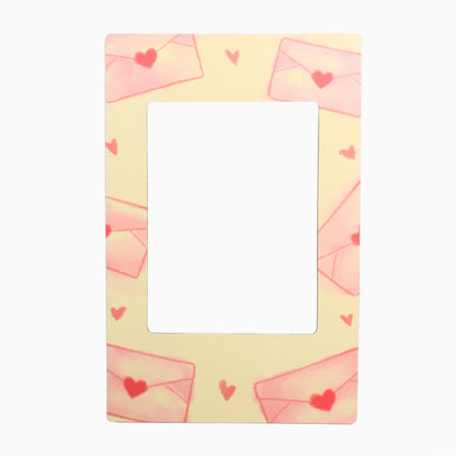 Decorative frame with pink envelopes and red hearts on a yellow background