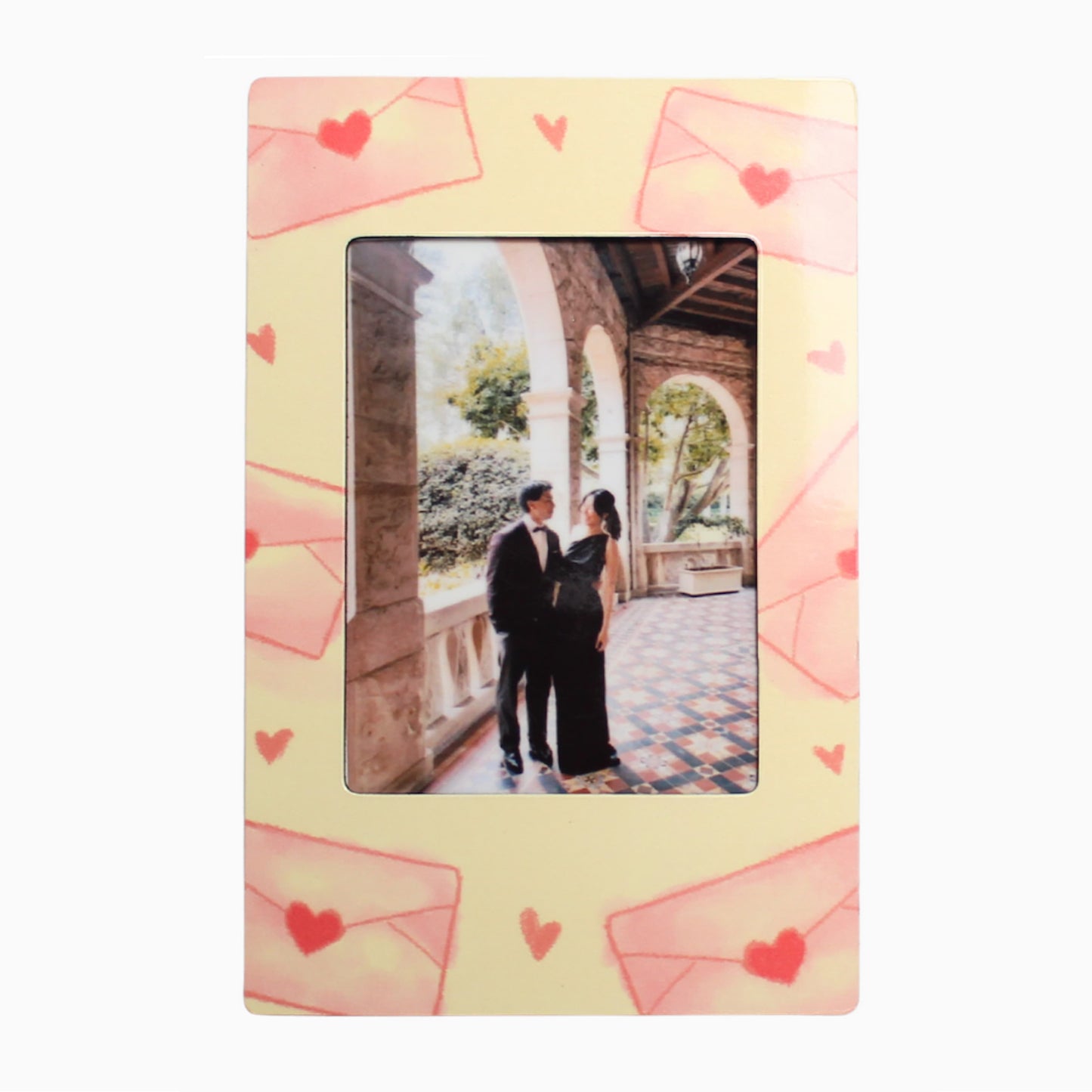 Decorative photo frame with heart designs and a couple in formal attire inside.